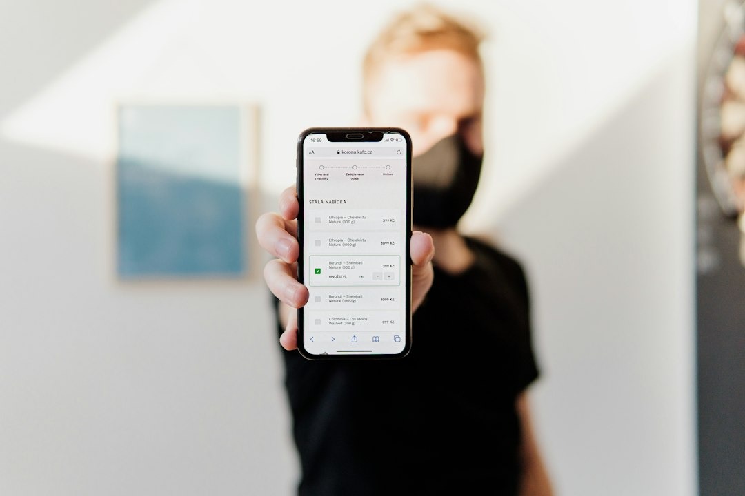 A person holds a smartphone showing a coffee e-commerce website.